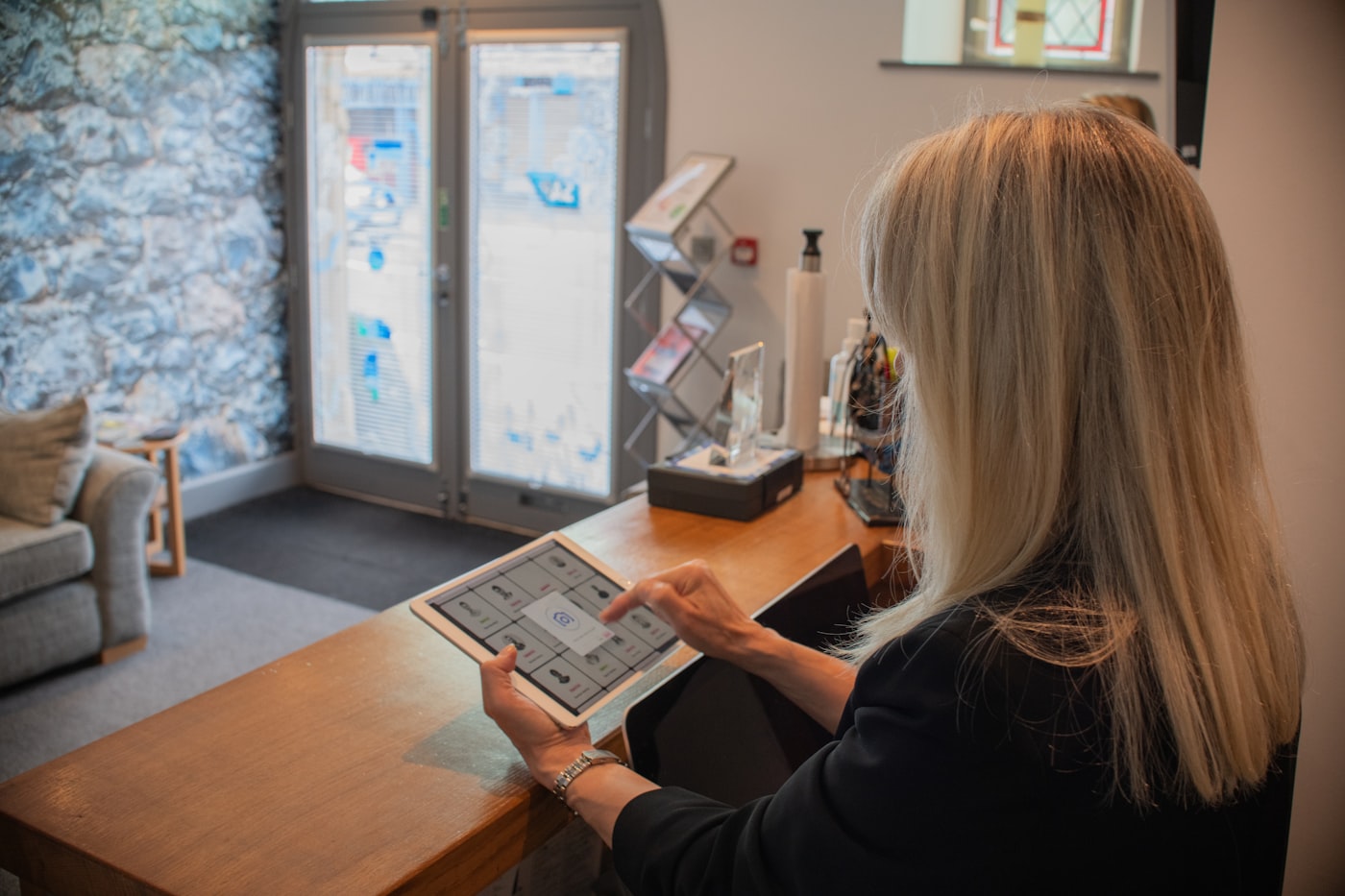Recepcionista de un centro de estética usando una tablet para agendar citas